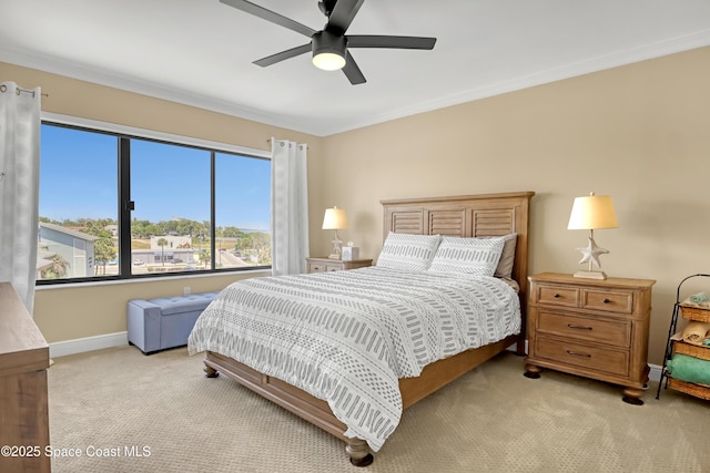 bedroom with baseboards, crown molding, a ceiling fan, and light carpet