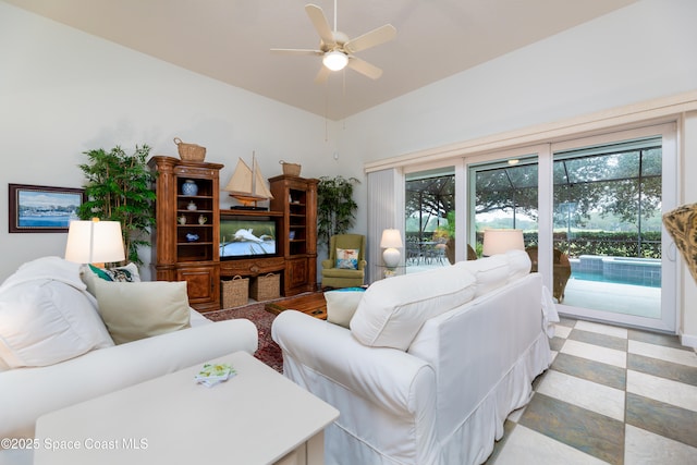 living room with ceiling fan, lofted ceiling, and light floors