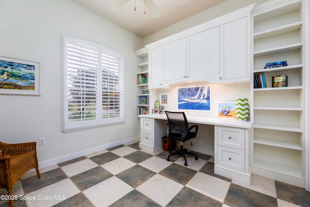office with baseboards, ceiling fan, a healthy amount of sunlight, and built in desk
