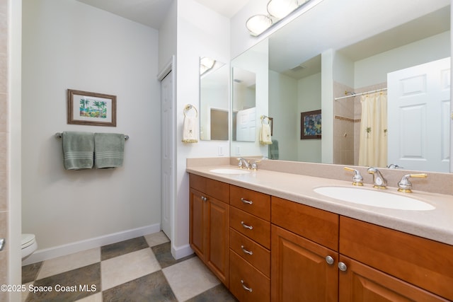 bathroom with a shower with curtain, double vanity, a sink, and baseboards