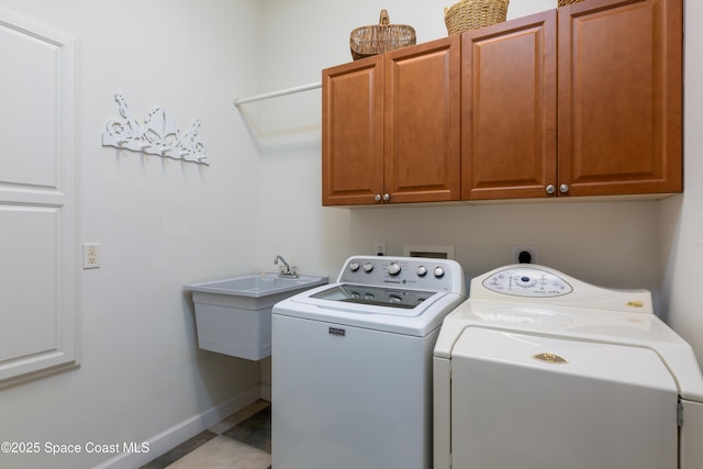 laundry area with a sink, cabinet space, independent washer and dryer, and baseboards