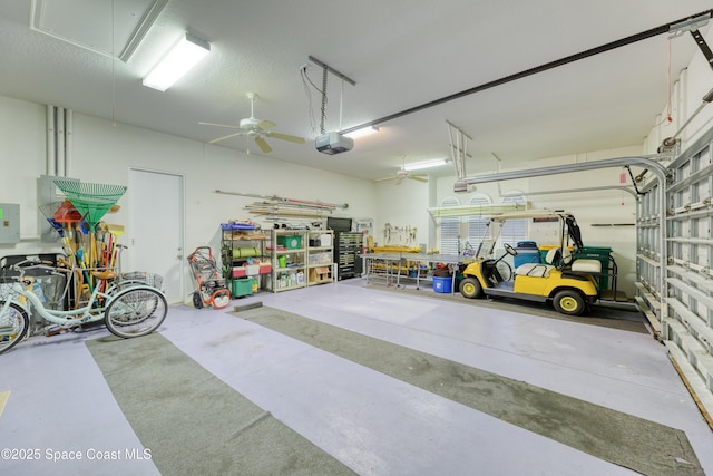 garage featuring a garage door opener, ceiling fan, and electric panel