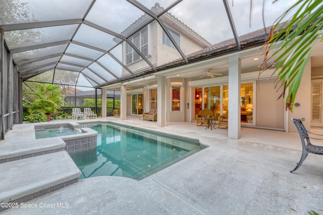 view of swimming pool featuring a patio, ceiling fan, glass enclosure, and a pool with connected hot tub