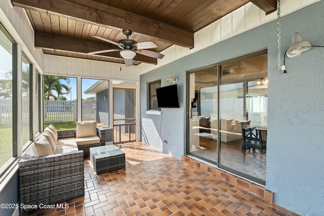 sunroom with an outdoor hangout area, a ceiling fan, and beam ceiling