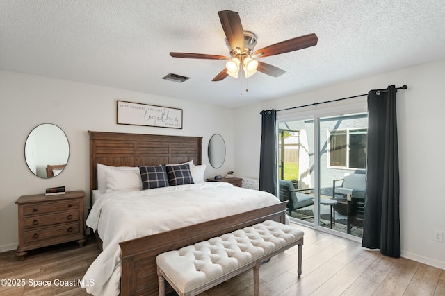 bedroom featuring a textured ceiling, access to exterior, light wood-type flooring, baseboards, and ceiling fan