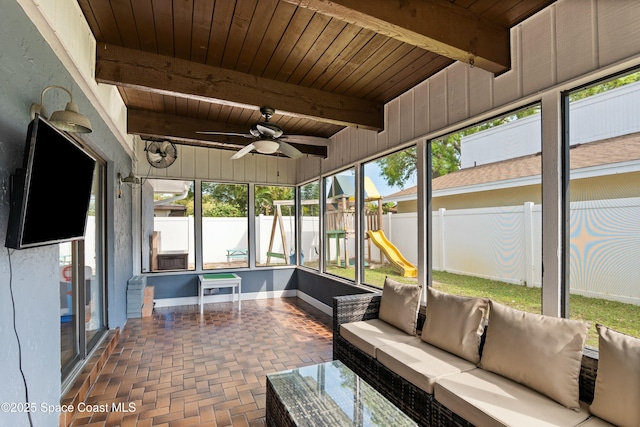 sunroom featuring a ceiling fan, outdoor lounge area, and beam ceiling