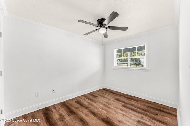 empty room featuring a textured ceiling, wood finished floors, and crown molding