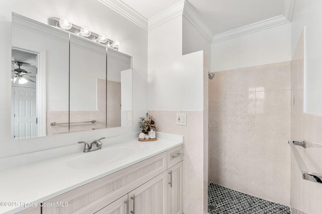 bathroom featuring a walk in shower, tile walls, ornamental molding, ceiling fan, and vanity