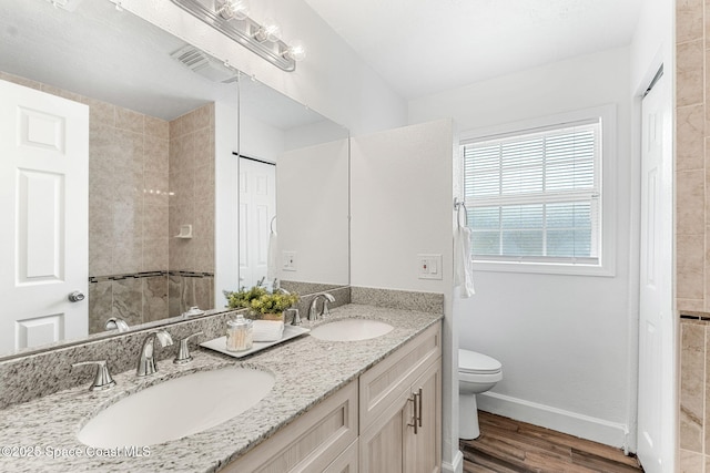 full bath with visible vents, wood finished floors, toilet, and a sink