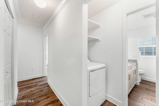 laundry room featuring visible vents, ornamental molding, wood finished floors, washer / dryer, and laundry area