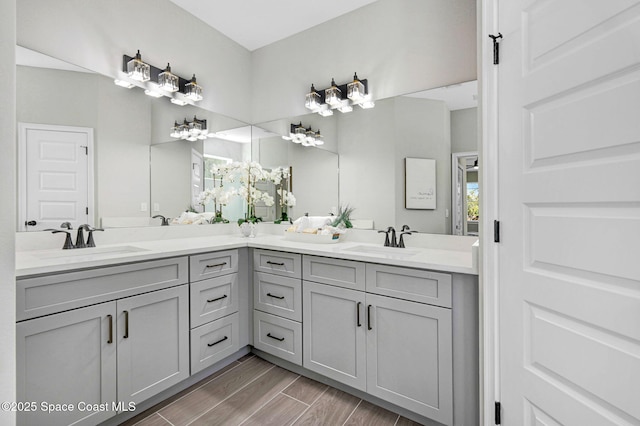 full bathroom with double vanity, a sink, and wood finished floors
