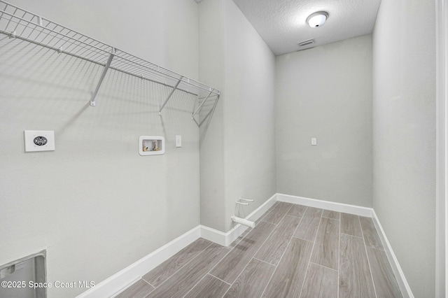 laundry area featuring washer hookup, laundry area, electric dryer hookup, baseboards, and wood finish floors