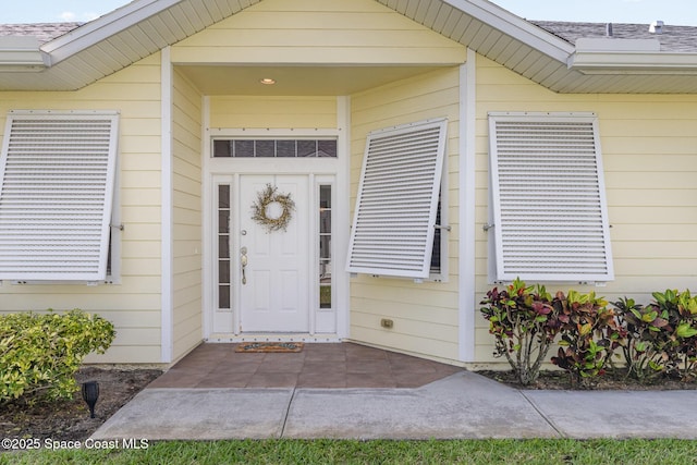 property entrance featuring a shingled roof