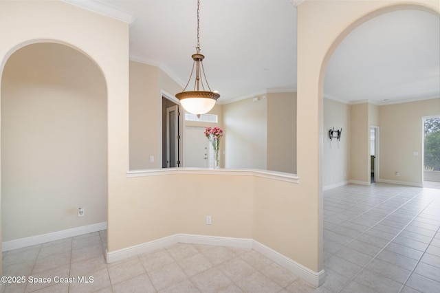 spare room with arched walkways, baseboards, ornamental molding, and tile patterned floors