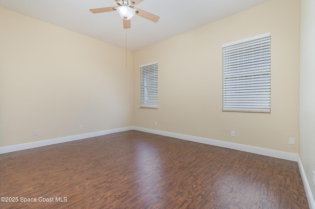 empty room with dark wood-type flooring, baseboards, and ceiling fan