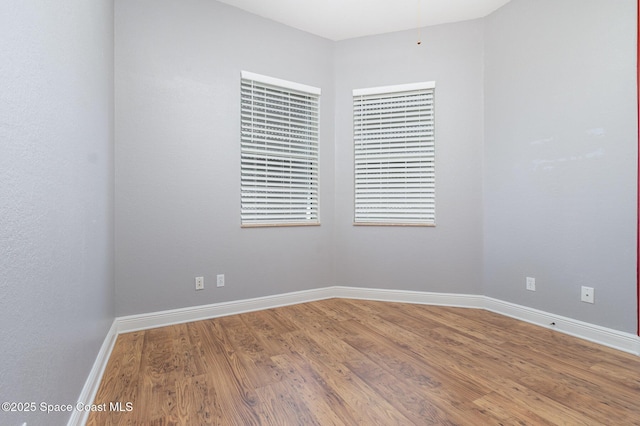 empty room with baseboards and wood finished floors