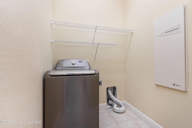washroom featuring baseboards, laundry area, washer / dryer, and light tile patterned floors