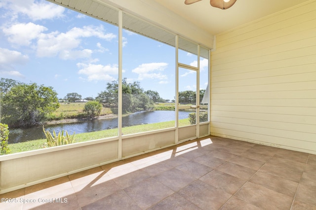 unfurnished sunroom featuring a water view and a ceiling fan