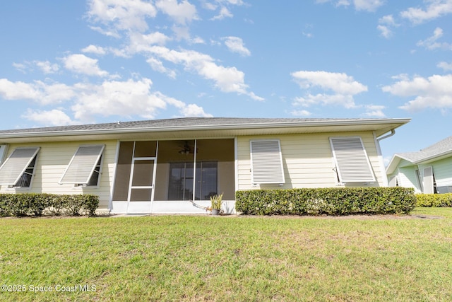 back of property featuring a sunroom, a ceiling fan, and a yard
