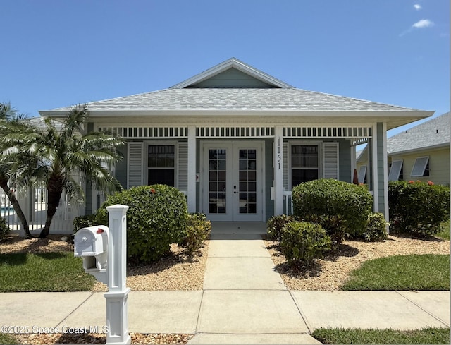 view of front of property featuring french doors and roof with shingles