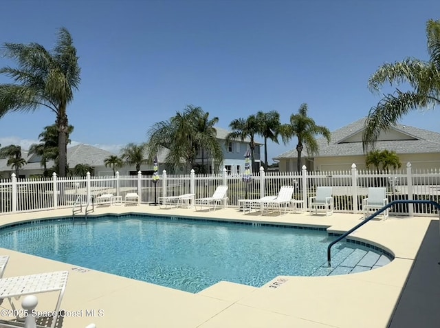pool featuring fence and a patio area