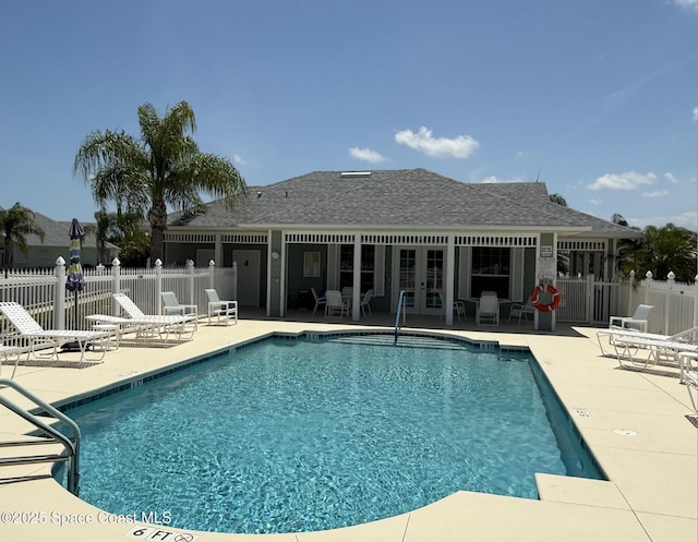 community pool with french doors, fence, and a patio