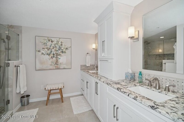 100 Riverside Dr Unit 701, Cocoa, FL 32922 - bathroom with baseboards, a shower stall, double vanity, and a sink