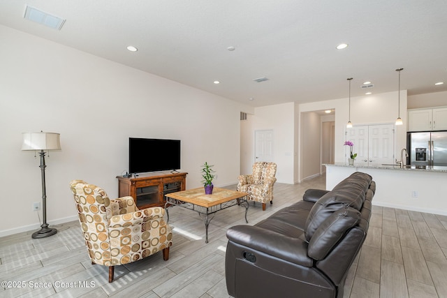 living area with wood tiled floor, baseboards, visible vents, and recessed lighting