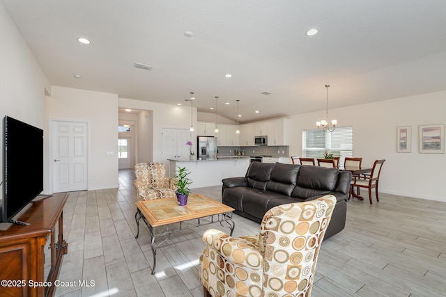 living area with recessed lighting, a notable chandelier, visible vents, and light wood-style floors