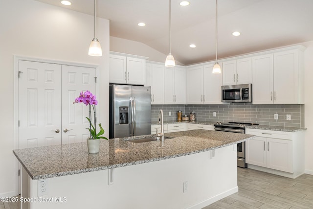 kitchen featuring white cabinets, decorative backsplash, stainless steel appliances, and a sink