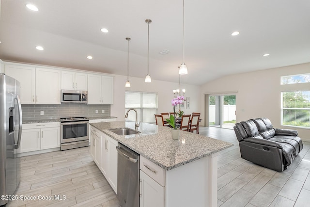 kitchen with a wealth of natural light, appliances with stainless steel finishes, wood finish floors, and a sink