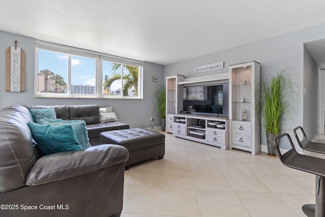 living room with baseboards and light tile patterned flooring