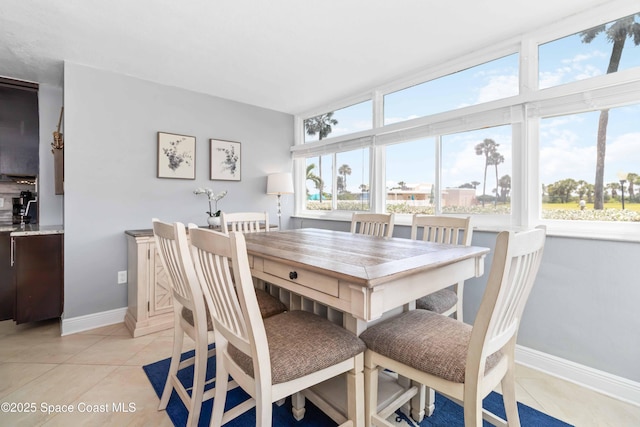 dining area featuring light tile patterned floors and baseboards