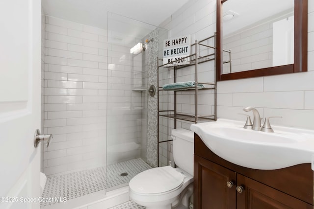 bathroom with vanity, toilet, tile walls, a walk in shower, and backsplash