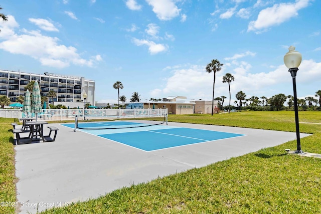 view of sport court with a lawn and fence