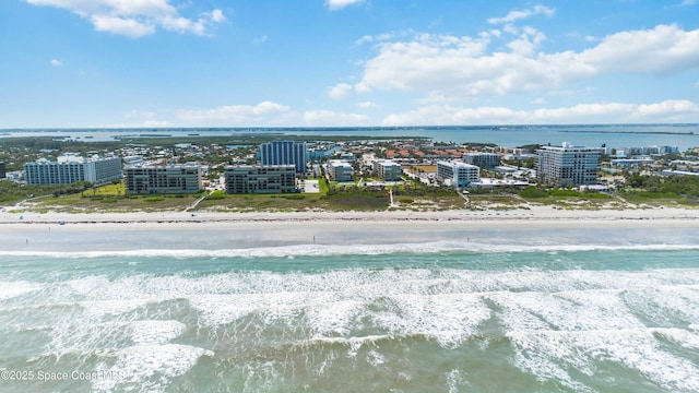 drone / aerial view featuring a beach view and a water view