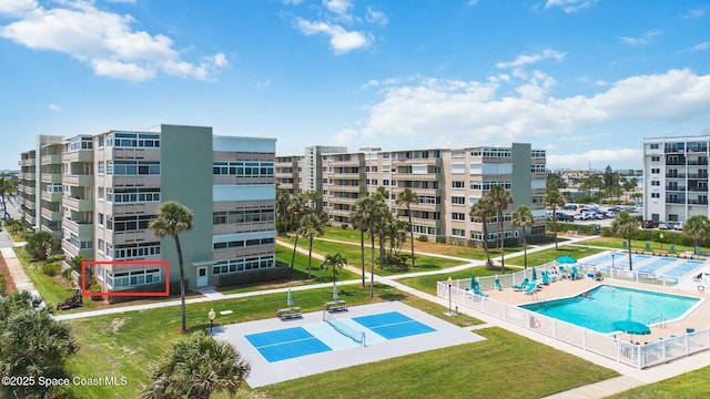 community pool featuring a lawn and fence