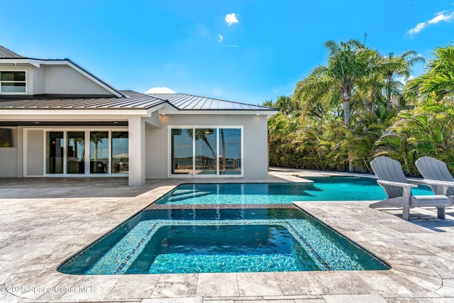 view of pool featuring a patio and a pool with connected hot tub