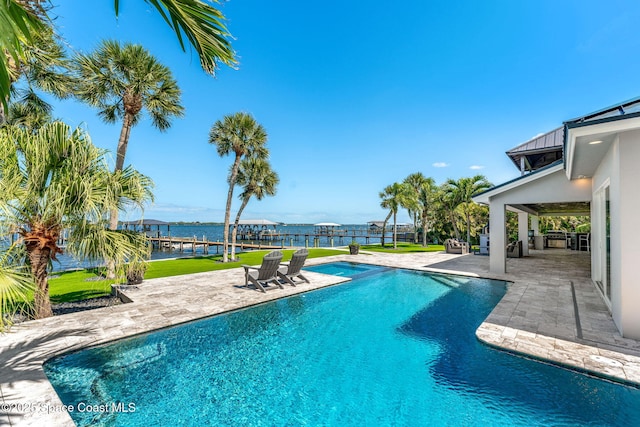 swimming pool featuring a patio and a water view