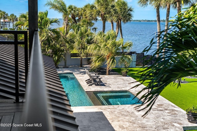 view of pool with a water view, a patio area, a pool, and fence