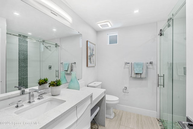 bathroom featuring a shower stall, vanity, toilet, baseboards, and recessed lighting