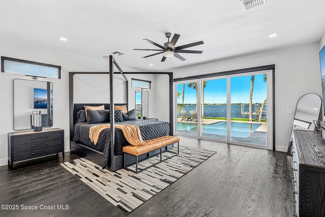 bedroom with access to outside, dark wood finished floors, baseboards, a water view, and recessed lighting
