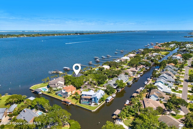 aerial view of property's location featuring a nearby body of water and nearby suburban area