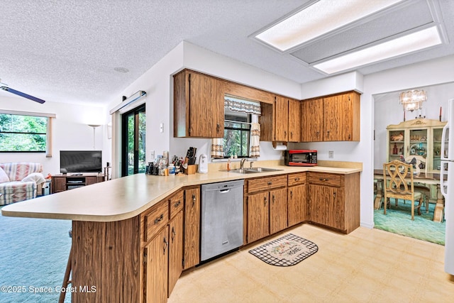 1812 Live Oak Dr N, Rockledge, FL 32955 - kitchen with stainless steel dishwasher, a peninsula, light countertops, a sink, and a wealth of natural light