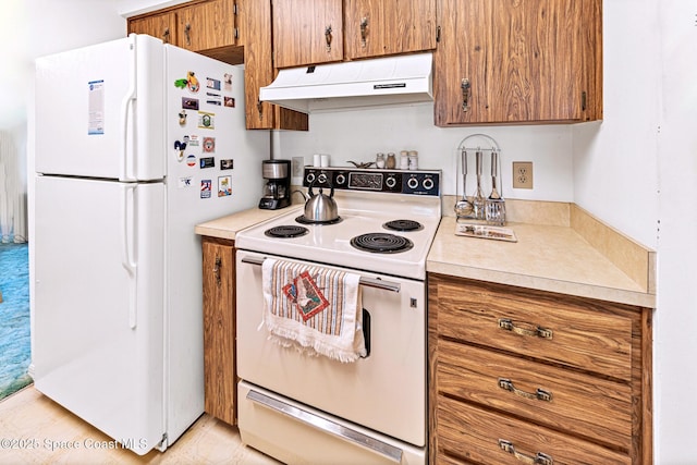 1812 Live Oak Dr N, Rockledge, FL 32955 - kitchen with white appliances, under cabinet range hood, brown cabinetry, and light countertops