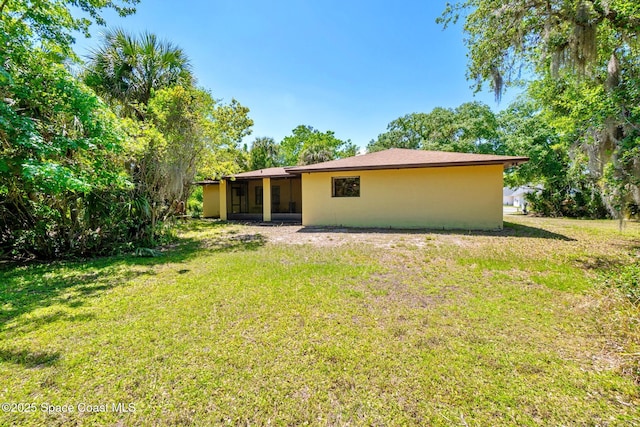 1812 Live Oak Dr N, Rockledge, FL 32955 - rear view of property with a sunroom, stucco siding, and a yard