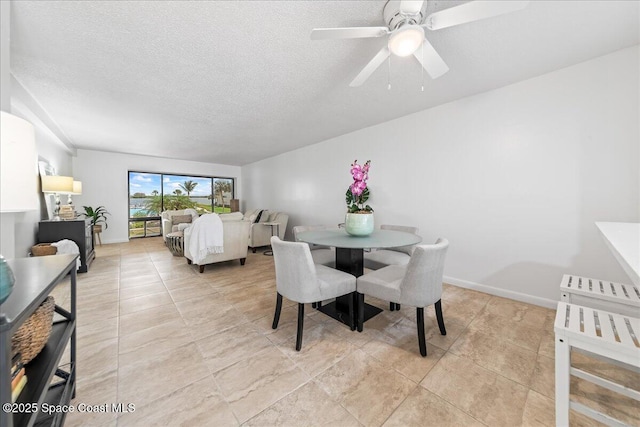 dining area with a textured ceiling, light tile patterned floors, and ceiling fan