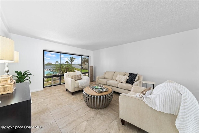 living area with a textured ceiling, baseboards, and light tile patterned flooring
