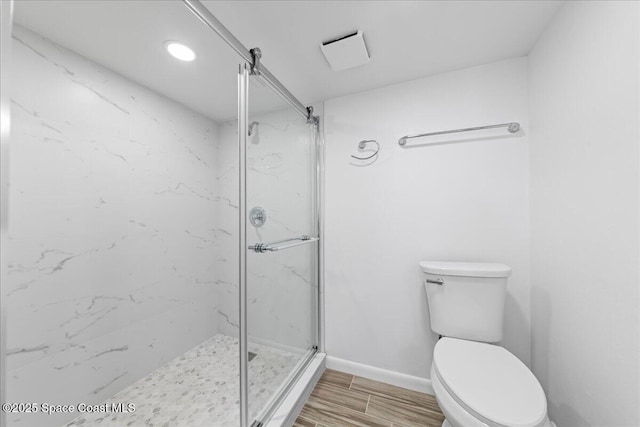 full bath with toilet, wood finished floors, a marble finish shower, recessed lighting, and baseboards