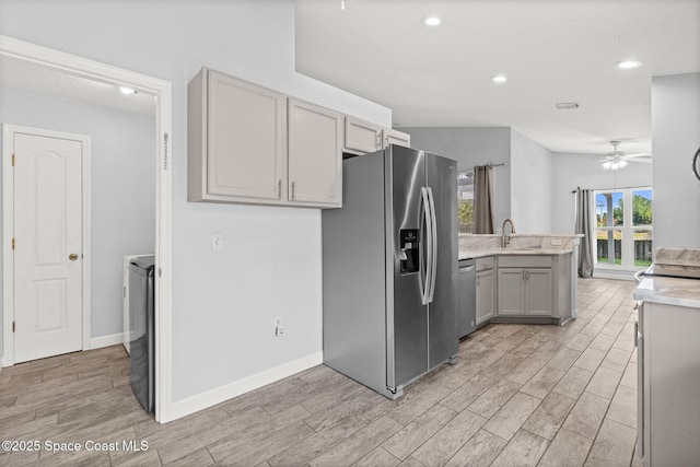 kitchen featuring a peninsula, light wood-type flooring, ceiling fan, gray cabinets, and appliances with stainless steel finishes